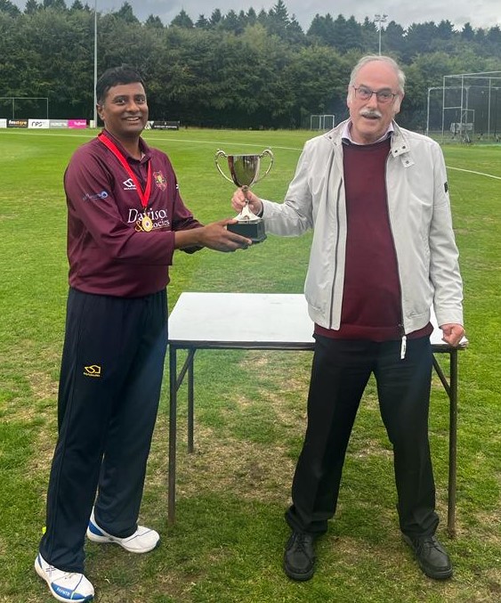 Darshan Kumar receiving the Midweek League Cup from Ian Hamilton